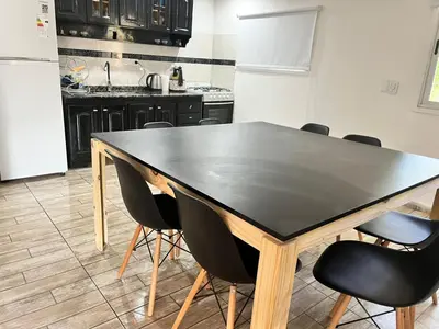 a kitchen with a black table and black chairs at Adonay VGB in Villa General Belgrano