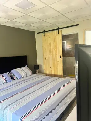 a bedroom with a large bed with a wooden door at Adonay VGB in Villa General Belgrano