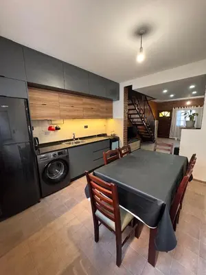 a kitchen with a black table and chairs and a sink at Duplex con patio y asador buena ubicacion in Villa Carlos Paz