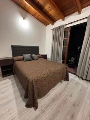a bedroom with a bed and a large window at Duplex con patio y asador buena ubicacion in Villa Carlos Paz