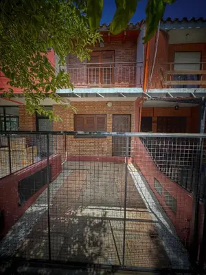 a fence in front of a brick building at Duplex con patio y asador buena ubicacion in Villa Carlos Paz
