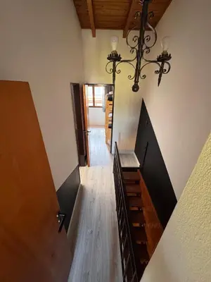 a hallway with a staircase with a chandelier at Duplex con patio y asador buena ubicacion in Villa Carlos Paz
