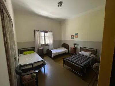 a room with two beds and a couch at La casona del rio in Nono