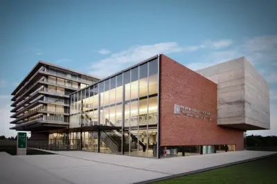 a large glass building with a red brick at Depto 24 en Barrio Villa Belgrano excelente ubicación in Cordoba