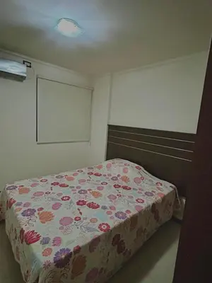a bedroom with a bed with a floral bedspread at depto en edificio miralejos 8 in Cordoba