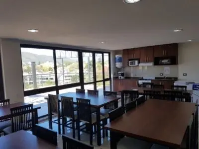 a dining room with tables and chairs and a kitchen at depto en edificio miralejos 8 in Cordoba