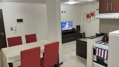 a kitchen with a table and chairs and a television at depto en edificio miralejos 8 in Cordoba