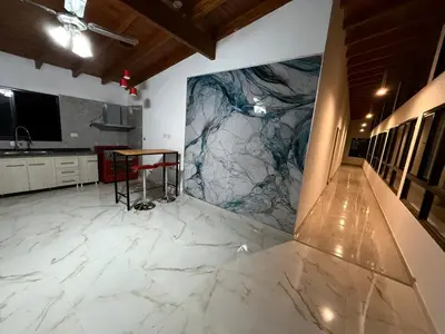 a kitchen with white marble flooring and a table at Valle Serrano in Mina Clavero