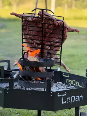 a grill with a piece of meat and fire at Valle Serrano in Mina Clavero