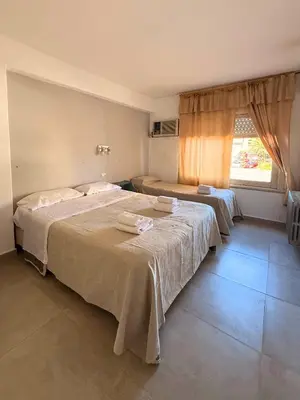 a bedroom with two beds and a window at Hotel Montecarlo PSH in Villa Carlos Paz