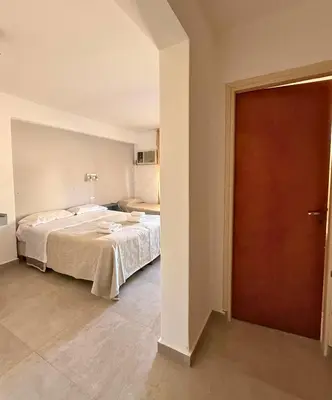 a bedroom with a bed and a wooden door at Hotel Montecarlo PSH in Villa Carlos Paz