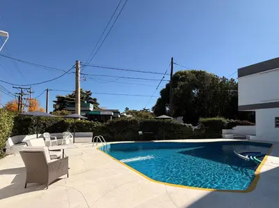 a swimming pool in a yard with chairs and a table at Hotel Montecarlo PSH in Villa Carlos Paz