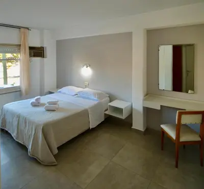 a bedroom with a bed with a chair and a mirror at Hotel Montecarlo PSH in Villa Carlos Paz