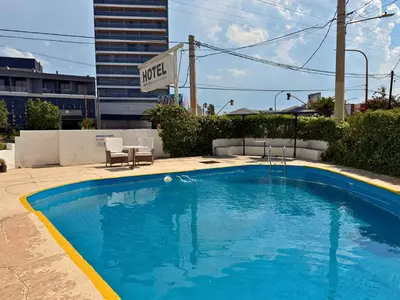 a large blue swimming pool next to a building at Hotel Montecarlo PSH in Villa Carlos Paz