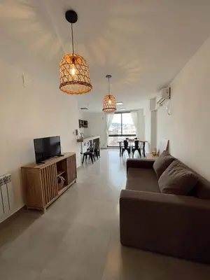 a living room with a couch and a dining room at Depa a Estrenar en el Centro, Pile, Aire Ac in Villa Carlos Paz