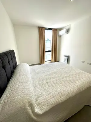 a bedroom with a large white bed with a window at Depa a Estrenar en el Centro, Pile, Aire Ac in Villa Carlos Paz
