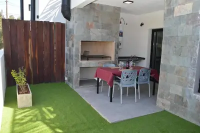 a patio with a table and chairs and a fireplace at Departamento en Villa Carlos paz in Villa Carlos Paz