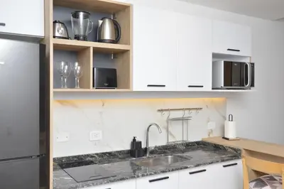 a kitchen with white cabinets and a sink at Departamento en Villa Carlos paz in Villa Carlos Paz