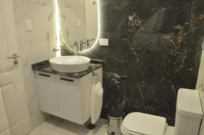 a black marble bathroom with a sink and a toilet at Departamento en Villa Carlos paz in Villa Carlos Paz