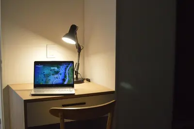 a laptop computer sitting on a desk with a lamp at Departamento en Villa Carlos paz in Villa Carlos Paz
