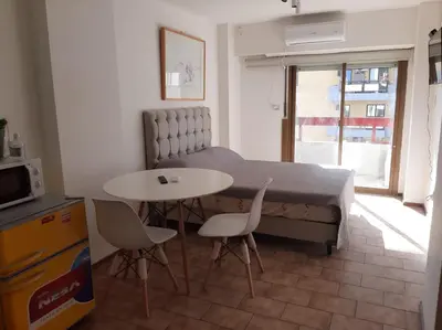 a bedroom with a bed and a table and chairs at Mono ambiente cómodo en pleno centro de Córdoba in Cordoba