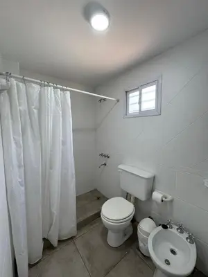 a white bathroom with a toilet and a window at Merlinda in Merlo