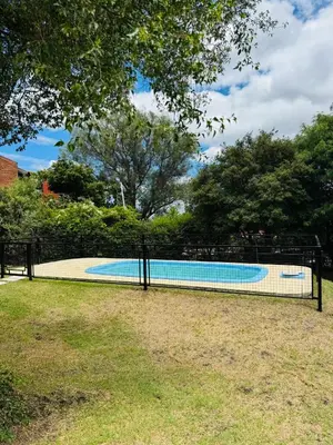 a fence around a swimming pool in a yard at Merlinda in Merlo