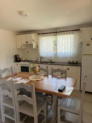 a kitchen with a wooden table and chairs and a kitchen with a refrigerator at Merlinda in Merlo