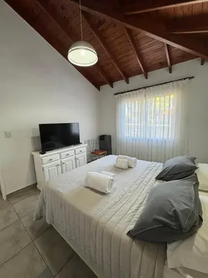 a bedroom with a large bed and a television at Merlinda in Merlo
