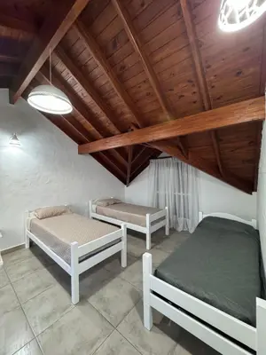two beds in a room with a wooden ceiling at Merlinda in Merlo