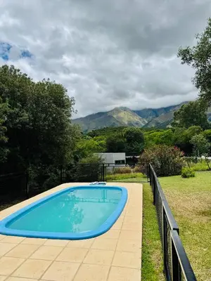 a blue swimming pool with mountains in the background at Merlinda in Merlo