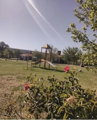 a park with a playground with a swing at Cabañas Don Luis in San Lorenzo