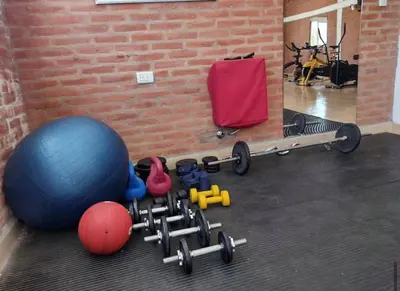 a room with a gym with a ball and weights at Cabañas Don Luis in San Lorenzo