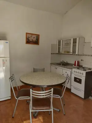 a kitchen with a table and chairs and a refrigerator at Cabañas Don Luis in San Lorenzo