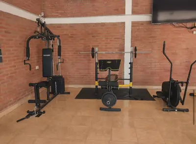 a gym with several exercise equipment in a brick wall at Cabañas Don Luis in San Lorenzo