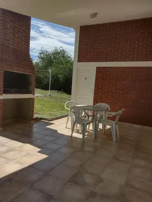 a patio with a table and chairs and a brick wall at Cabañas Don Luis in San Lorenzo