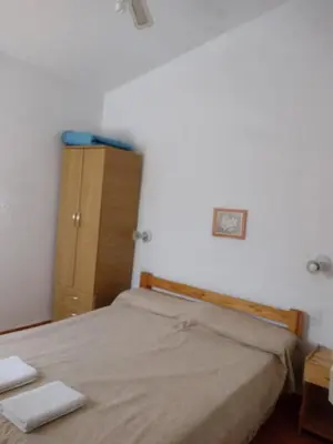 a small bedroom with a bed and a dresser at Cabañas Don Luis in San Lorenzo
