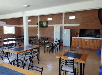 a dining room with tables and chairs and a refrigerator at Cabañas Don Luis in San Lorenzo