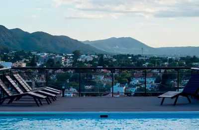 two chairs sitting on a balcony with a view of a city at Miralejos VII - Edificio Premium - Departamento 1 Dormitorio in Villa Carlos Paz