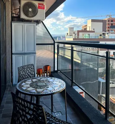 a balcony with a table and chairs and a view at Miralejos VII - Edificio Premium - Departamento 1 Dormitorio in Villa Carlos Paz