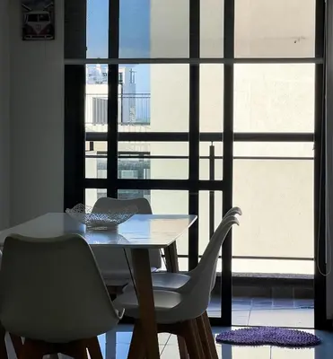 a dining room table and chairs in front of a window at Miralejos VII - Edificio Premium - Departamento 1 Dormitorio in Villa Carlos Paz