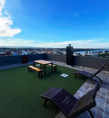 a patio with a table and a bench on a roof at Miralejos VII - Edificio Premium - Departamento 1 Dormitorio in Villa Carlos Paz