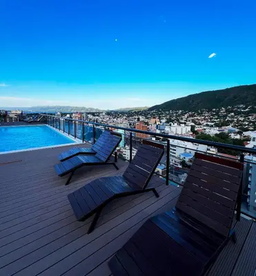 two chairs on a deck with a view of a city at Miralejos VII - Edificio Premium - Departamento 1 Dormitorio in Villa Carlos Paz