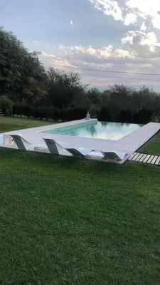 a large swimming pool in a grass field at LunaNegra Casas de descanso in Villa General Belgrano