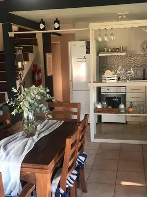 a kitchen with a table and a refrigerator at LunaNegra Casas de descanso in Villa General Belgrano