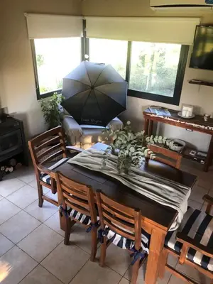a dining room with a table and an umbrella at LunaNegra Casas de descanso in Villa General Belgrano