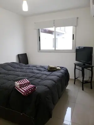 a bedroom with a bed and a flat screen tv at Viamonte deluxe Barrio General Paz 2 dormitorios in Cordoba