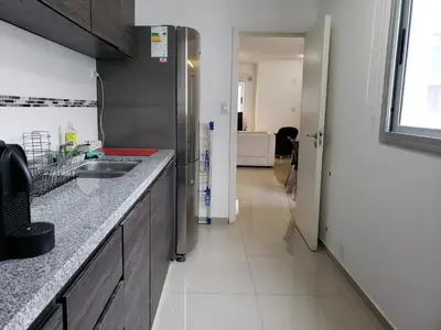 a kitchen with a counter and a sink and a hallway at Viamonte deluxe Barrio General Paz 2 dormitorios in Cordoba