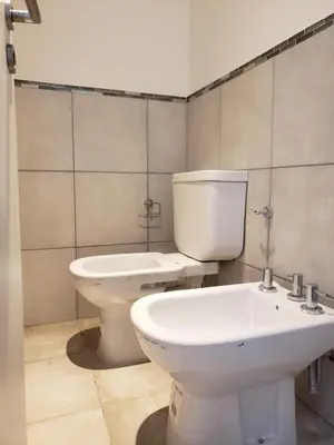 a bathroom with a white toilet and a sink at Viamonte deluxe Barrio General Paz 2 dormitorios in Cordoba