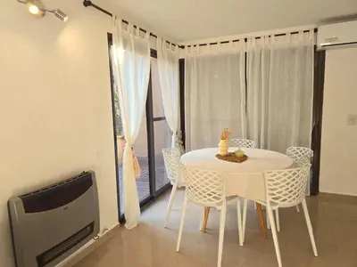a white table and chairs in a room with a window at FlussHaus3 in Villa General Belgrano